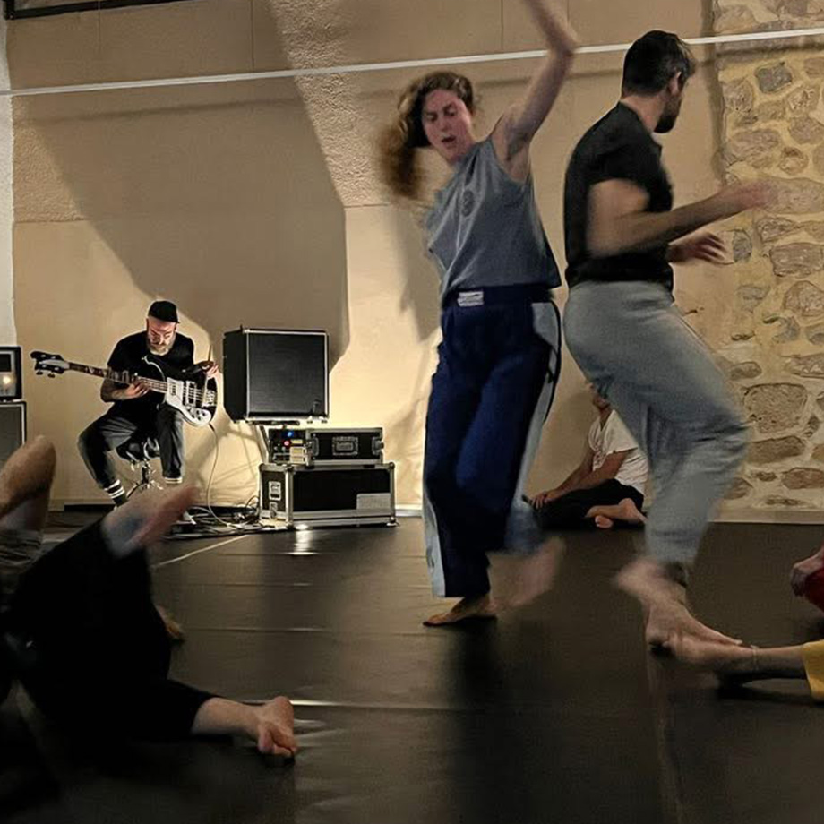 Participants moving during a collective improvisation accompanied by Ludovic Gerst performing frise lumière at To Mikro Studio in Aegina